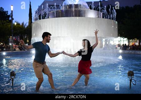 (230717) -- TEL AVIV, July 17, 2023 (Xinhua) -- People dance near a fountain at Dizengoff Square, during a heat wave in Tel Aviv, Israel, on July 16, 2023. (Tomer Neuberg/JINI via Xinhua) Stock Photo