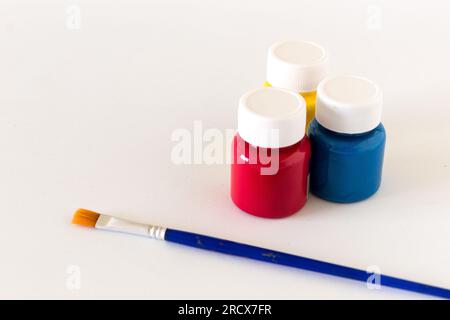 Bottles of primary color and brush on white background. Ideas and concepts. Copy space Stock Photo