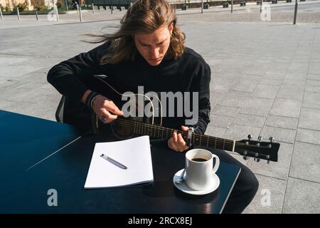 man playing the guitar and studing music Stock Photo