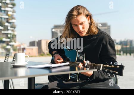 man playing the guitar and studing music composition Stock Photo