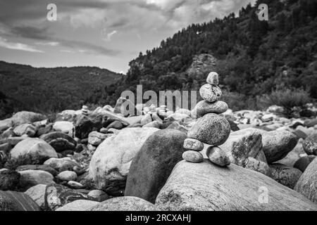 Zen small pile of stones, shallow focus perspective in front of Devil's bridge over river Arda, Southern Bulgaria. Black and white travel picture Stock Photo