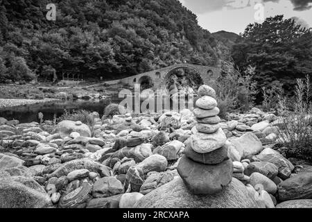 Zen small pile of stones, shallow focus perspective in front of Devil's bridge over river Arda, Southern Bulgaria. Black and white travel picture Stock Photo