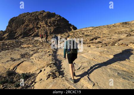 Walkers in the landscape of the Beidha valley before Little Petra, Al-Sharat area of Jordan, Middle East Stock Photo