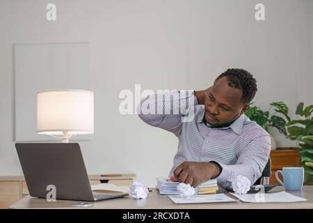 Tired depressed bored african businessman by business failure bankruptcy looking at laptop feel exhausted having headache, upset stressed black office Stock Photo