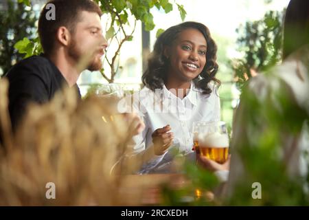 Friends, co-workers meeting together after work, celebrating projects, spending lovely time together , drinking beer at pub, cafe Stock Photo
