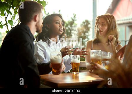 Friends, co-workers meeting together after work, celebrating projects, spending lovely time together , drinking beer at pub, cafe Stock Photo