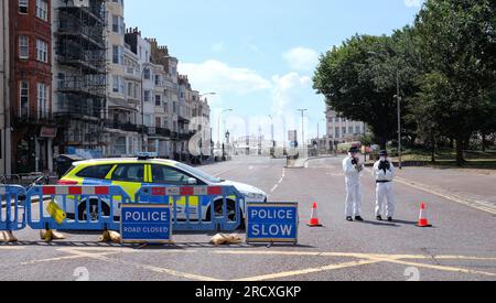Brighton UK 17th July 2023 - Police and PCSO's wearing protective suits and masks because of the lingering smoke in the air as the streets are still closed around The Royal Albion Hotel in Brighton after the major fire over the weekend  : Credit Simon Dack / Alamy Live News Stock Photo