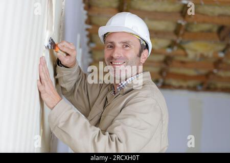 builder in hardhats with plastering tools indoors Stock Photo
