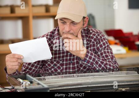 repairman repairing checking instructions Stock Photo