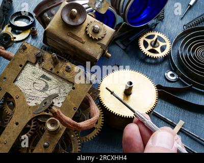 Close-up of a repairman hand assembling or repairing a vintage mechanical robot. Stock Photo
