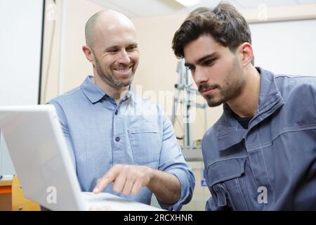 young man being trained at office desk Stock Photo