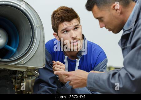 apprentice technician asking his foreman a question Stock Photo