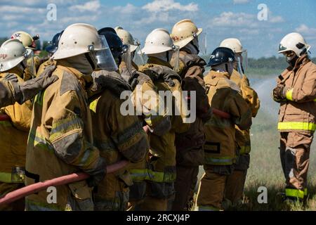 Firefighters and rescue training. Firefighter spraying high pressure water to fire Burning fire flame background Stock Photo