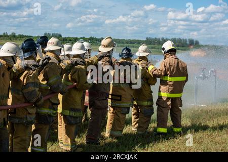 Firefighters and rescue training. Firefighter spraying high pressure water to fire Burning fire flame background Stock Photo