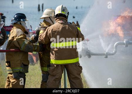 Firefighters and rescue training. Firefighter spraying high pressure water to fire Burning fire flame background Stock Photo