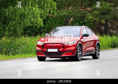 Red battery electric Ford Mustang Mach-E compact crossover SUV car at speed on road on a day of summer. Salo, Finland. July 6, 2023. Stock Photo