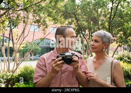 Senior couple looking at each other while standing in the park Stock Photo