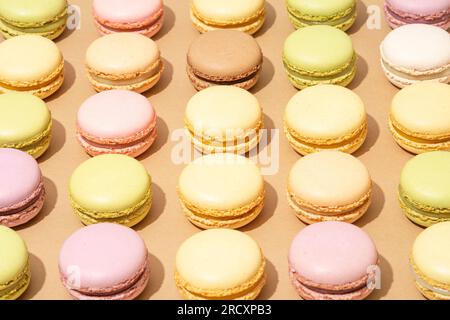 An assortment of macarons are neatly arranged in rows on a flat surface Stock Photo