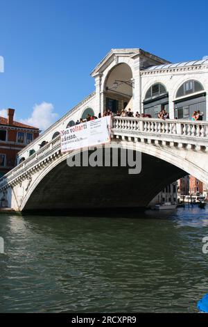 VENICE, ITALY - SEPTEMBER 16, 2009: Tourists walk Rialto bridge across Canal Grande in Venice, Italy. Venice Old Town is a UNESCO World Heritage Site. Stock Photo