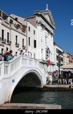 VENICE, ITALY - SEPTEMBER 16, 2009: Tourists walk Pieta bridge (Ponte de la Pieta) crossing a canal in Venice, Italy. Venice Old Town is a UNESCO Worl Stock Photo