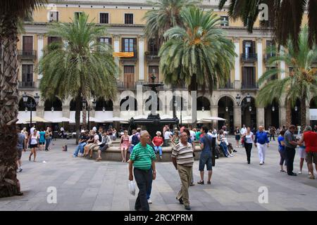 BARCELONA, SPAIN - SEPTEMBER 12, 2009: People visit Placa Reial public square in Barcelona, Spain. Placa Reial is located in Barri Gotic district. Stock Photo