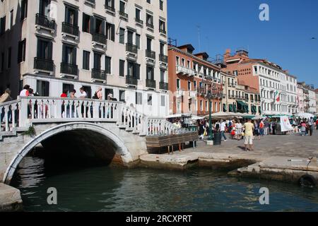 VENICE, ITALY - SEPTEMBER 16, 2009: Tourists walk the bridge crossing Rio del Vin canal in Venice, Italy. Venice Old Town is a UNESCO World Heritage S Stock Photo