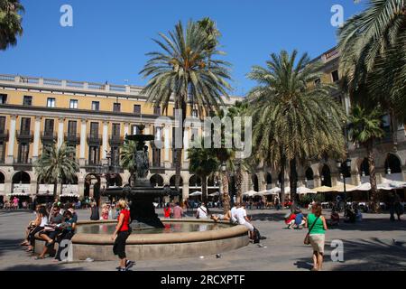 BARCELONA, SPAIN - SEPTEMBER 9, 2009: People visit Placa Reial public square in Barcelona, Spain. Placa Reial is located in Barri Gotic district. Stock Photo