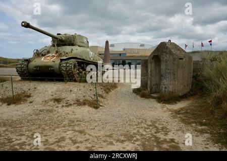Sherman Tank outside the entrance to The Utah Beach Museum, on sand under a cloudy sky. Utah Beach, France, July 3, 2023. Stock Photo