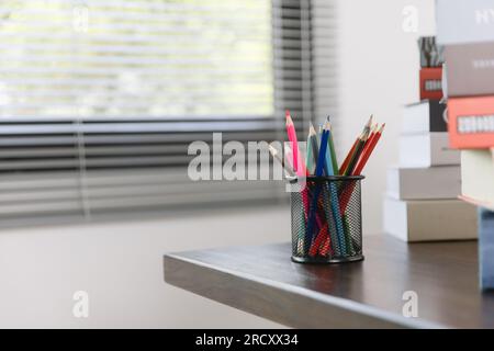 School supplies on wooden table in warm interior, school books on table, education concept. Stock Photo