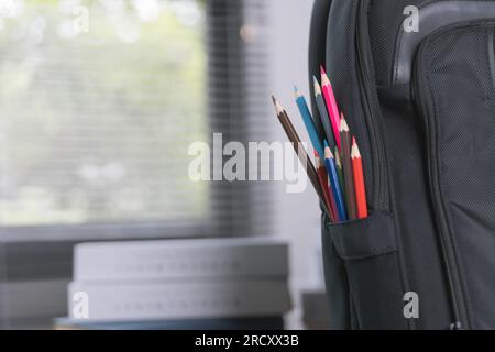 School supplies on wooden table in warm interior, school books on table, education concept. Stock Photo