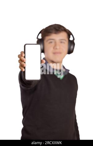 Caucasian boy with headphones out of focus shows the blank screen of his mobile phone isolated on a white background. Stock Photo