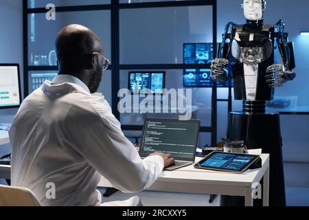 Rear view of African American engineer typing codes on computer in the lab Stock Photo