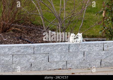 2 small white frog figures sitting on a wall. High quality photo Stock Photo