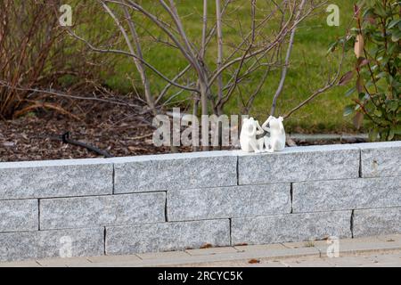 2 small white frog figures sitting on a wall. High quality photo Stock Photo