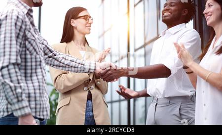 Multiethnic group of inspired young people standing and discussing new project in conference room Stock Photo