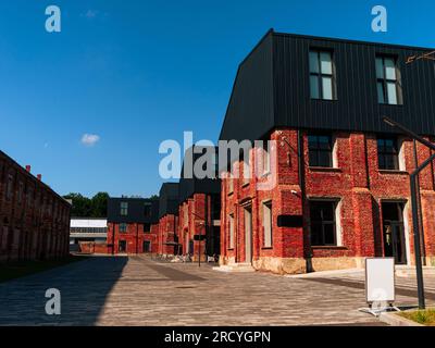 Modern cafe workspace exterior loft style red brick wall Old industrial building renovation. Creative urban space Break-out area city loft conversion Stock Photo