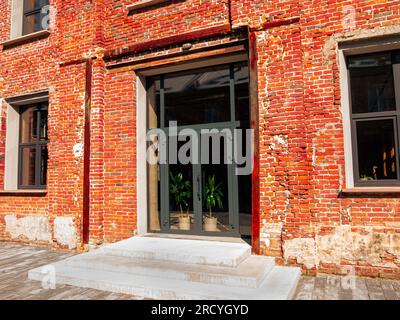 Modern cafe workspace exterior loft style red brick wall Old industrial building renovation. Creative urban space Break-out area city loft conversion Stock Photo