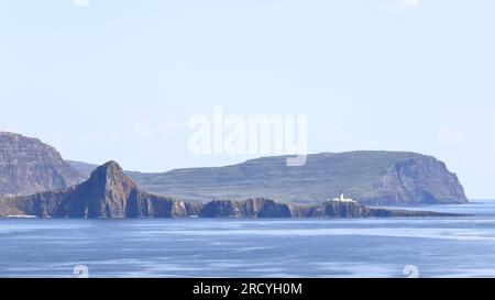 Neist Point Lighthouse.  The view from a ship as it sails past the coastline of the Isle of Skye.  Neist Point Lighthouse can be seen on Neist Point. Stock Photo