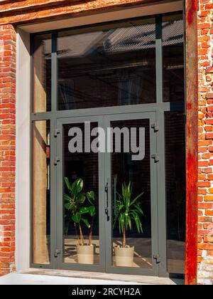 Modern cafe workspace exterior loft style red brick wall Old industrial building renovation. Creative urban space Break-out area city loft conversion Stock Photo