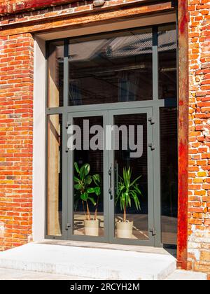 Modern cafe workspace exterior loft style red brick wall Old industrial building renovation. Creative urban space Break-out area city loft conversion Stock Photo