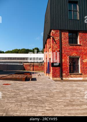 Modern cafe workspace exterior loft style red brick wall Old industrial building renovation. Creative urban space Break-out area city loft conversion Stock Photo