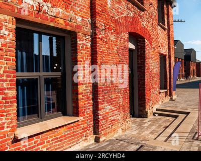 Modern cafe workspace exterior loft style red brick wall Old industrial building renovation. Creative urban space Break-out area city loft conversion Stock Photo