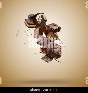 Assorted chocolate pralines floating with melted chocolate splash on brown background Stock Photo