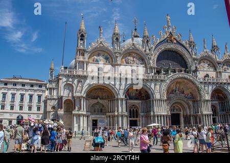 Details of St Mark's Basilica or the Basilica di San Marco in Italian, golden mosaics, intricate carvings, and statues adorn the roof of St. Mark's Stock Photo