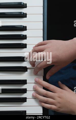 Music school. Piano chords two hands playing exersizes. Keys on the synthesizer keyboard close-up Stock Photo