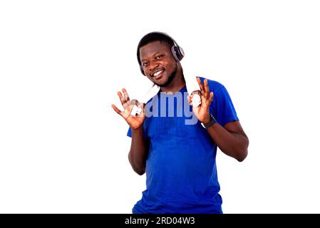 portrait of a handsome sporty young man listening to music on headphones holding a towel around his neck while smiling. Stock Photo