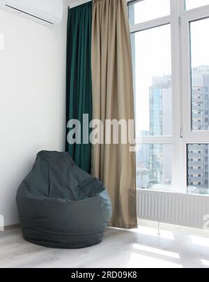 frameless gray armchair near the  window Scandinavian design, bedrooms, interior, minimalism Stock Photo
