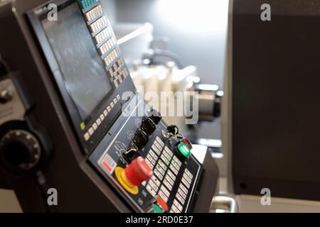 Industrial metalworking CNC lathe machine with control console in the foreground. Selective focus. Stock Photo