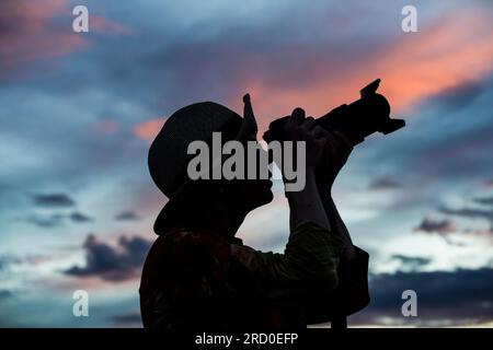 Silhouette of Photographer at dusk on Madre de Dios River bank in Peru. Stock Photo