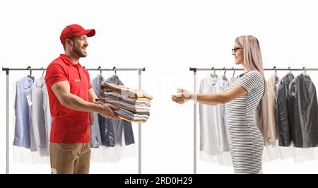 Man delivering a pile of folded clothes to a young woman at the dry cleaners isolated on a white background Stock Photo